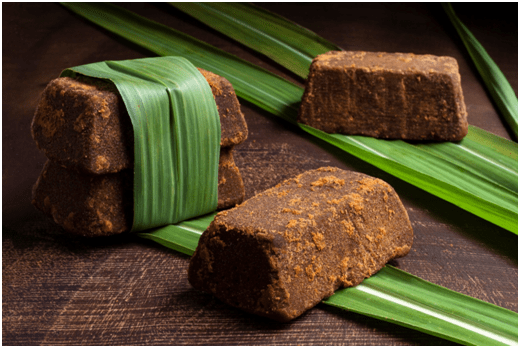 Bloack of Palm Jaggery is tied with palm tree fronds