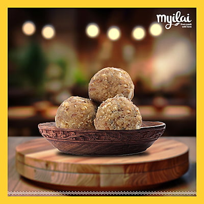 A bowl of MYILAI SPECIAL LADDU in placed in centre with milai logo on top